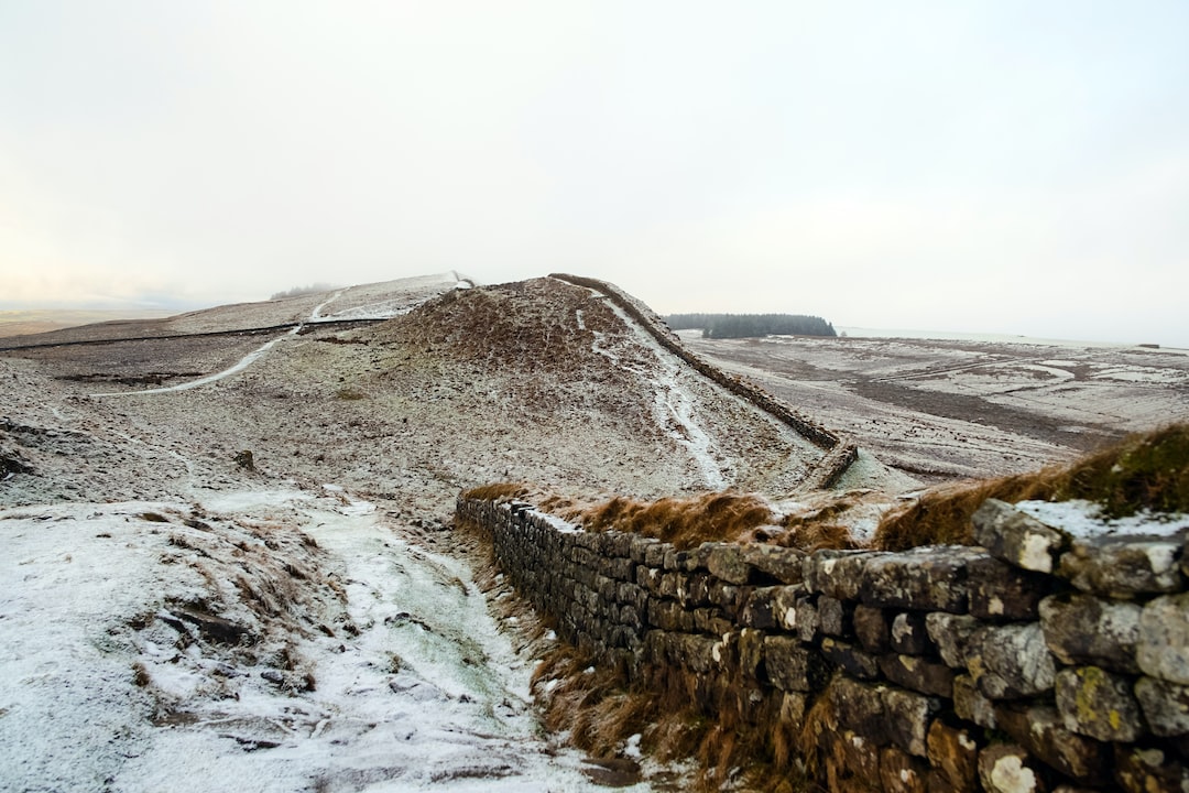 landscape photography of grey bricked wall near mountain
