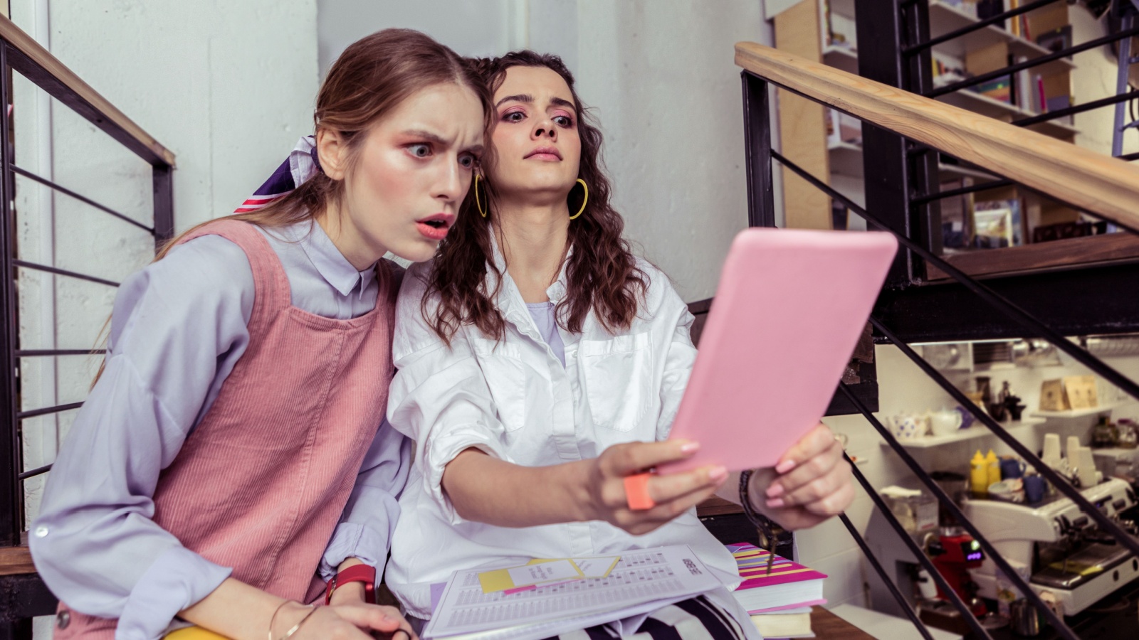 Girls being terrified. Terrified and scared girls being confused with information on tablet and looking unbelievably