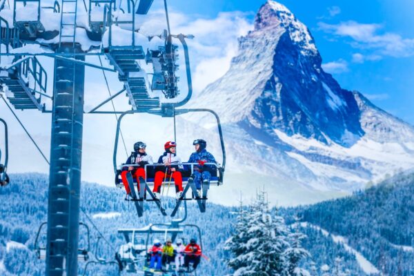 Zermatt switzerland skiers in a ski lift against a white snowy mountain