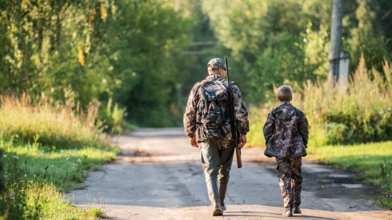 father pointing and guiding son on first deer hunt