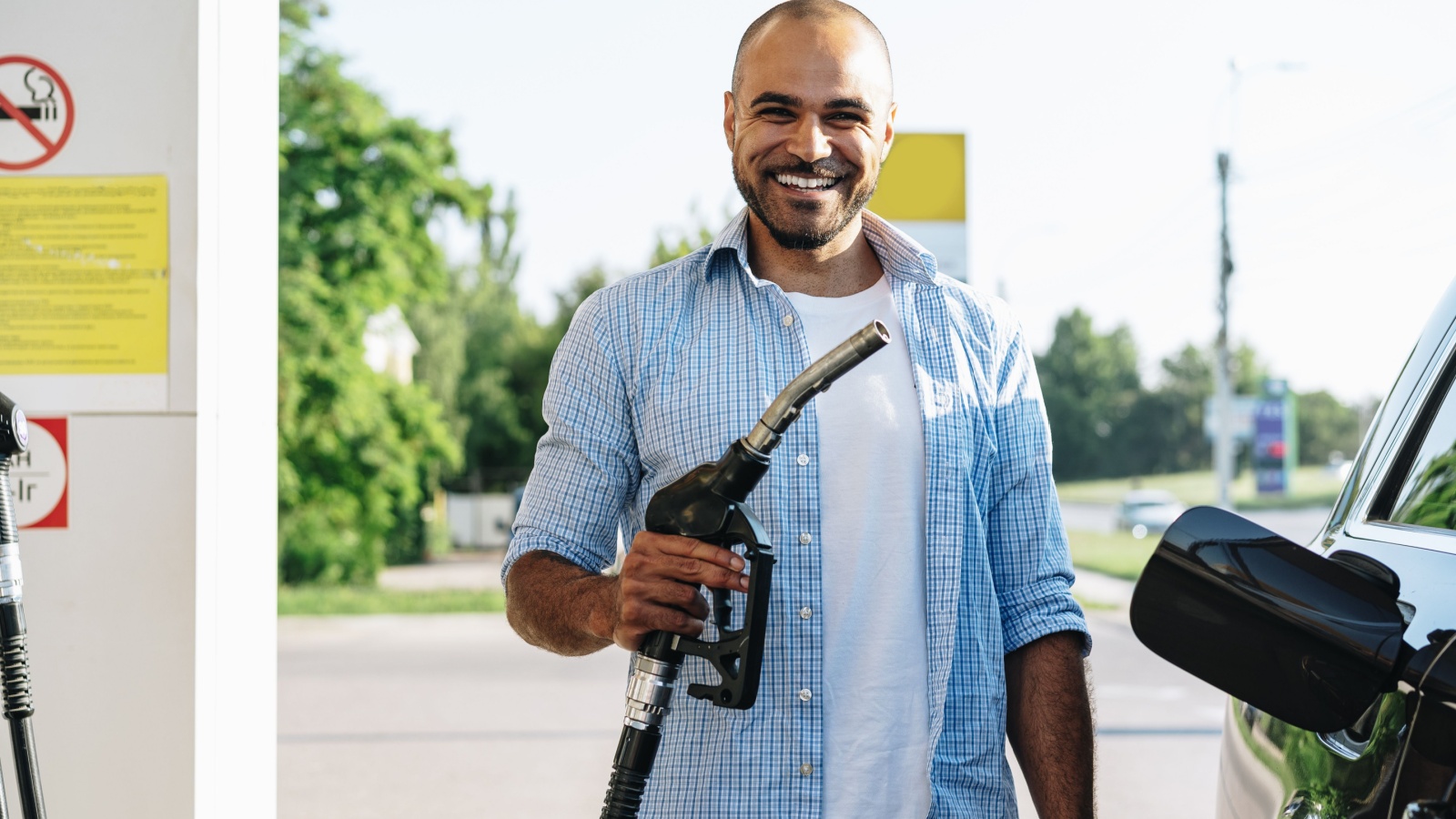 Man filling gasoline fuel in car at gas station