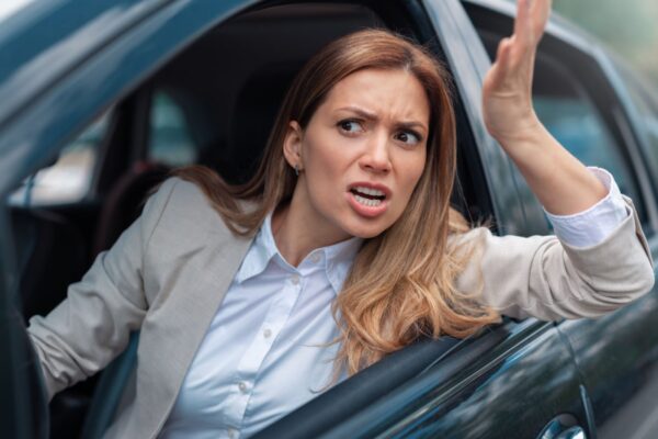 Road rage traffic jam concept. Woman is driving her car very aggressive