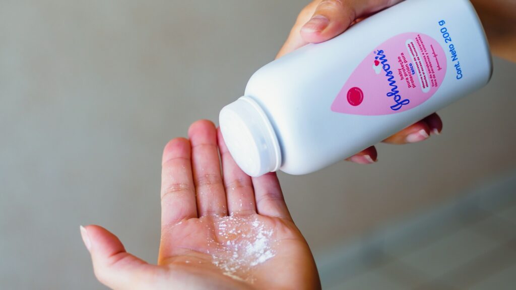 August 25, 2022, Brazil. In this photo illustration, a person uses Johnson Johnson baby powder on their hands. The company will suspend the sale of the product from 2023