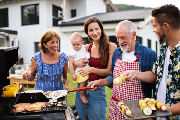 Portrait of multigeneration family outdoors on garden barbecue, grilling.