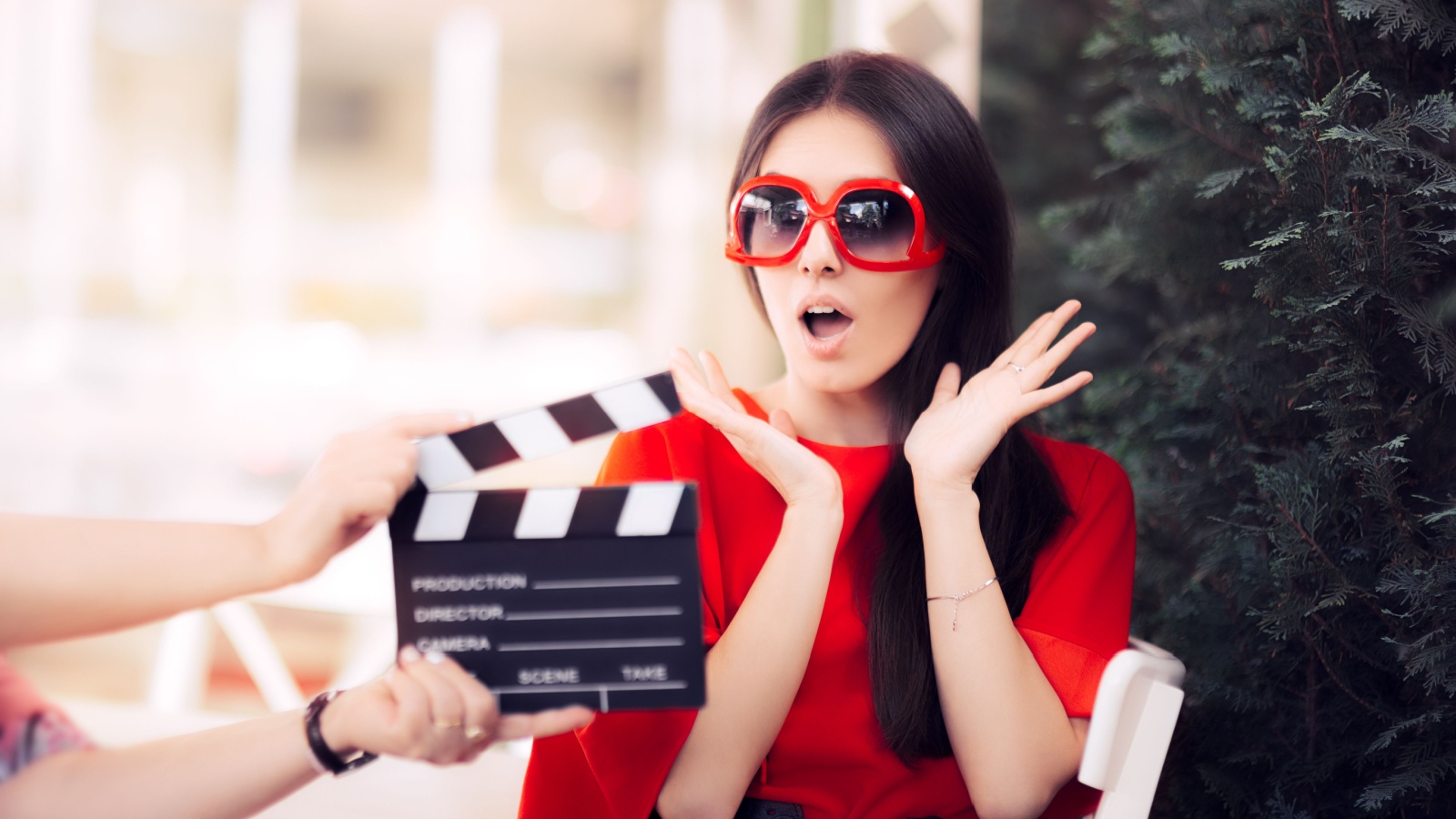 Surprised Actress with Oversized Sunglasses Shooting Movie Scene - Diva in red dress and big shades starring in an artistic film