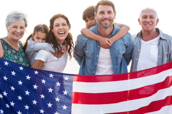 Happy family with an american flag at the beach