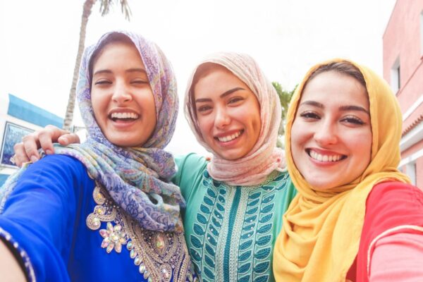 Islamic young friends taking selfie with smartphone camera outdoor - Happy arabian girls having fun with new trend technology - Friendship and millennial app concept - Focus on faces