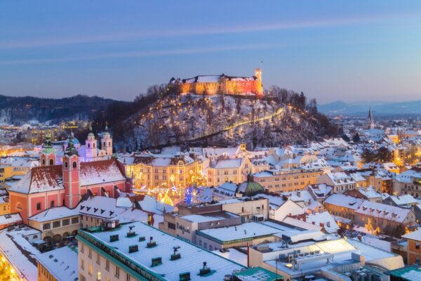 Aerial panoramic view of Ljubljana decorated for Christmas holidays. Roofs covered in snow in winter time. Slovenia, Europe.