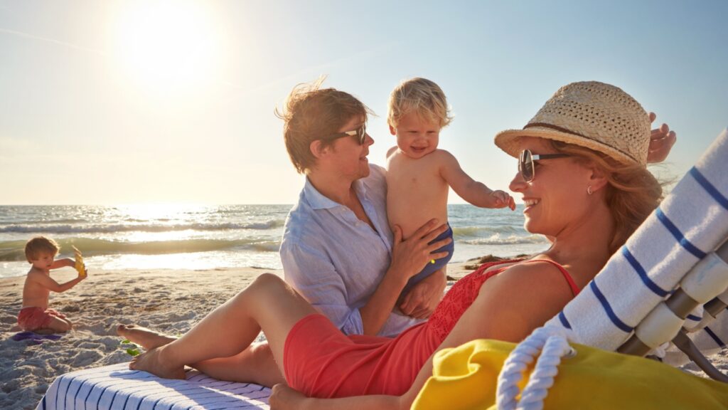 Chair, sunset or family with woman at beach on holiday vacation or weekend together with dad or kids. Father, calm mother or children siblings at sea for bonding or break in nature in Spain in summer