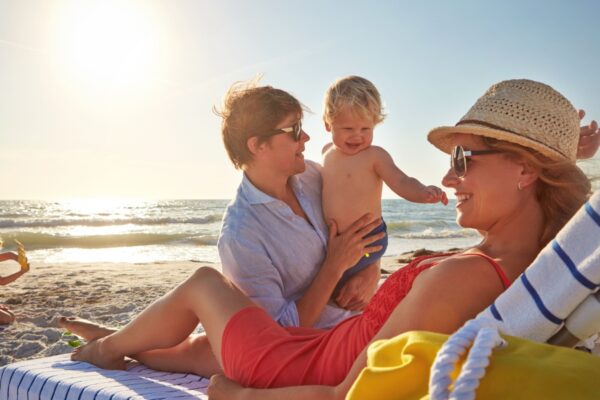 Chair, sunset or family with woman at beach on holiday vacation or weekend together with dad or kids. Father, calm mother or children siblings at sea for bonding or break in nature in Spain in summer