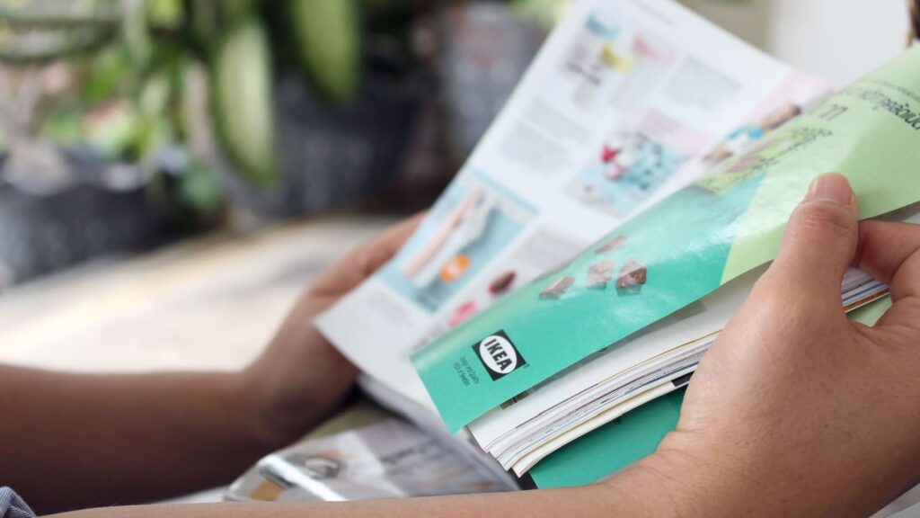 Rayong, Thailand - January 3rd, 2018: A lady outside in a garden reads an IKEA catalog in Thai language. IKEA currently has three stores in Thailand.