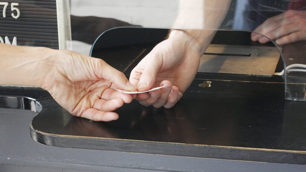 Buying a ticket at a ticket booth.