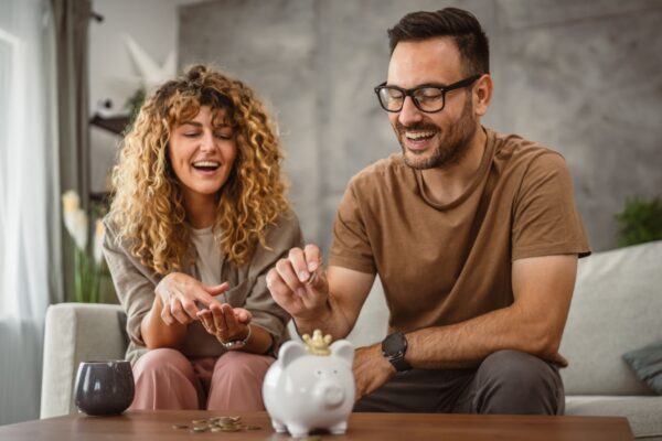 Adult couple wife and husband save money together in the piggy bank