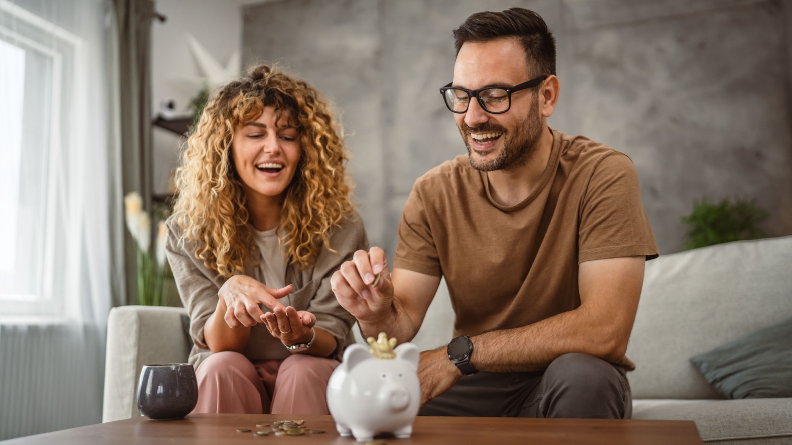 Adult couple wife and husband save money together in the piggy bank