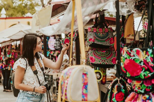 traveler girl buying souvenirs in the traditional Mexican market in Mexico streets, hispanic tourists standing in outdoor