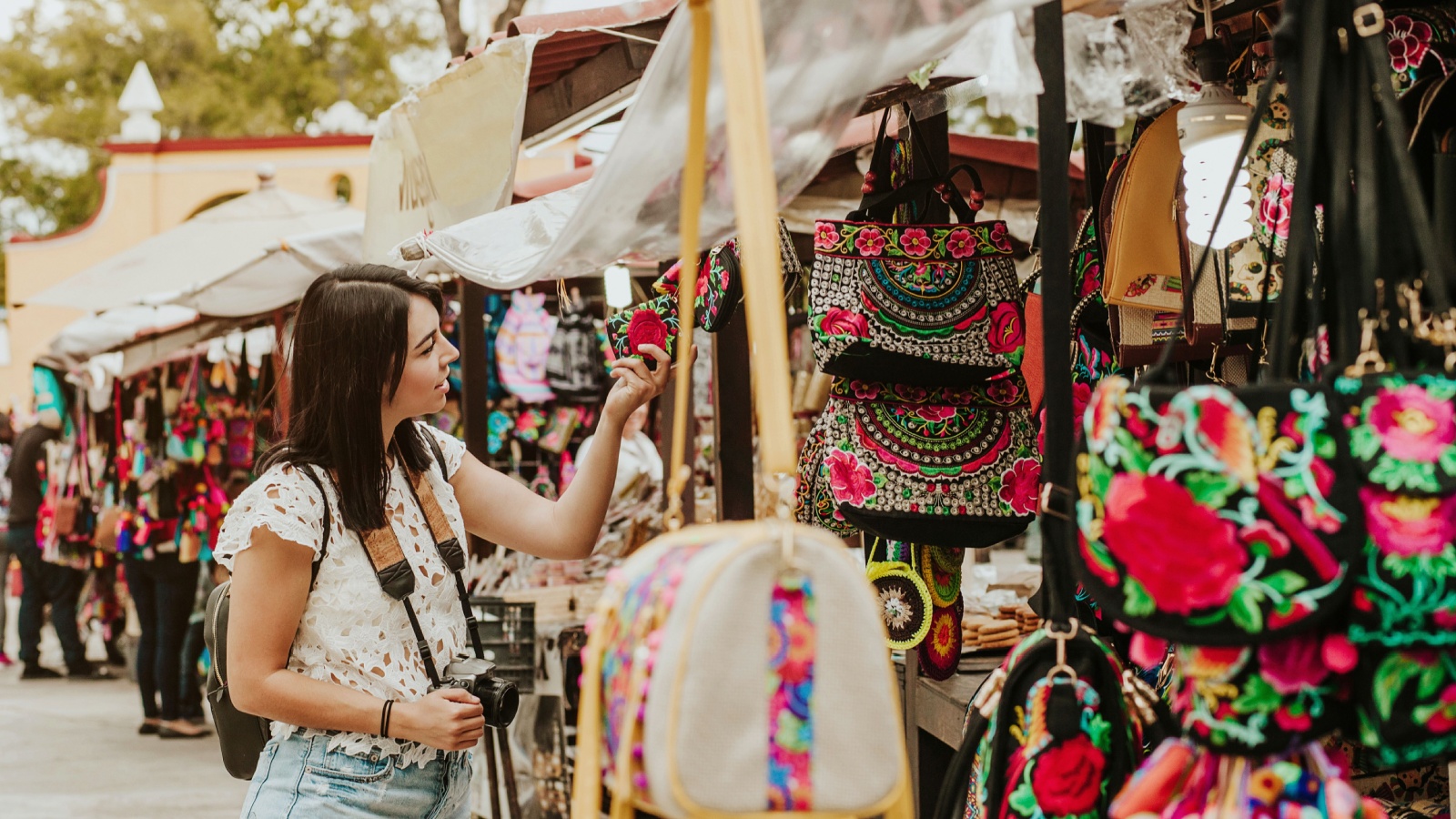 traveler girl buying souvenirs in the traditional Mexican market in Mexico streets, hispanic tourists standing in outdoor