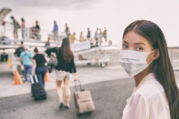 COVID-19 Travel Airport Asian woman tourist boarding plane for holiday wearing face mask. PPE Corona virus Coronavirus negative test and vaccine passport banner panoramic.