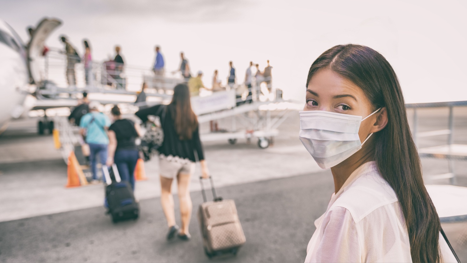 COVID-19 Travel Airport Asian woman tourist boarding plane for holiday wearing face mask. PPE Corona virus Coronavirus negative test and vaccine passport banner panoramic.