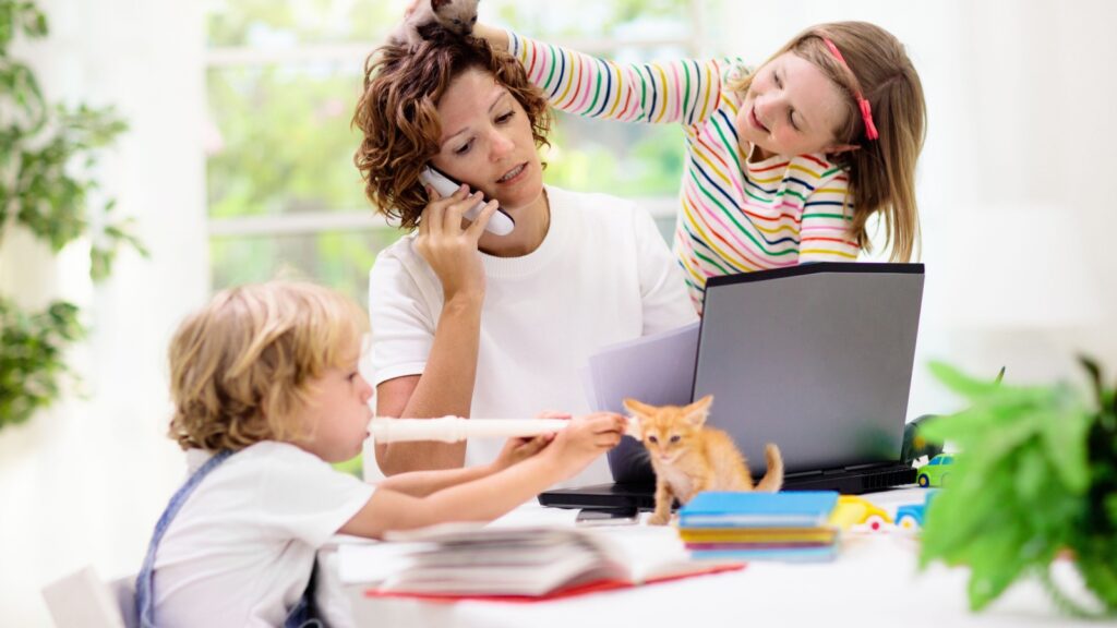 Mother working from home with kids. Quarantine and closed school during coronavirus outbreak. Children make noise and disturb woman at work.