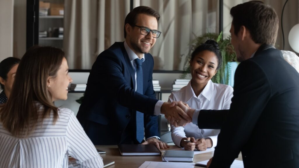 Nice to meet you in our team. Friendly man leader boss shake hand of new staff member welcome young male on job in corporate department.