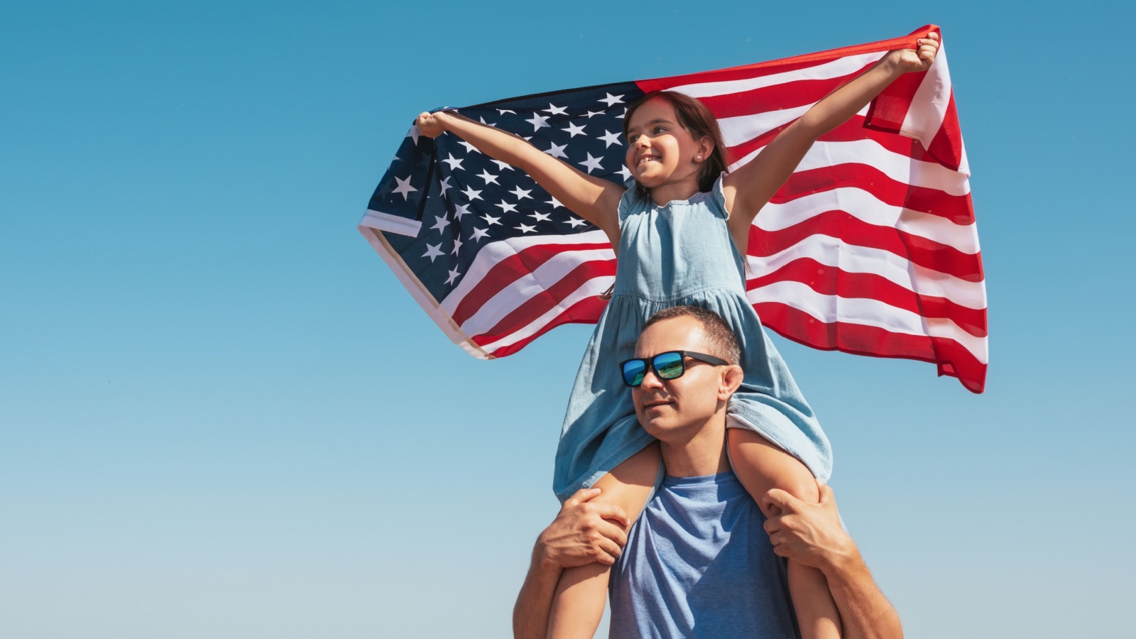 Happy family father and child with usa flag enjoy nature on sky background. Free lifestyle.