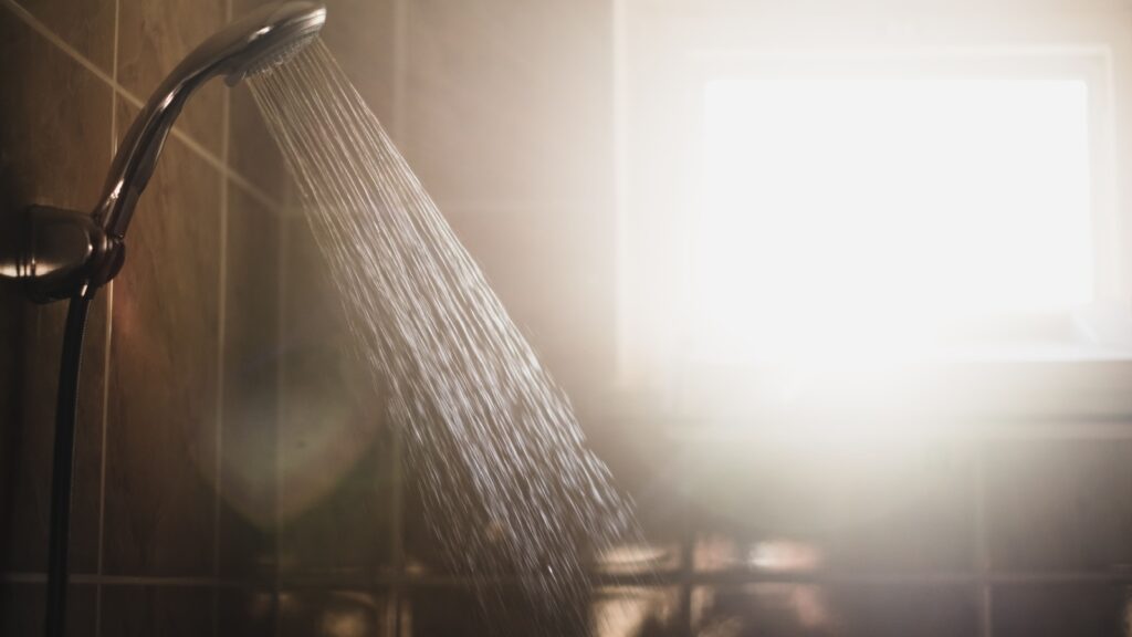 shower with flowing water and steam with window on background.