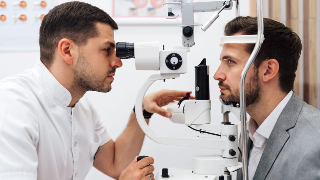 Attractive male doctor ophthalmologist is checking the eye vision of handsome middle age man in modern clinic. Doctor and patient during medical check up in ophthalmology clinic.