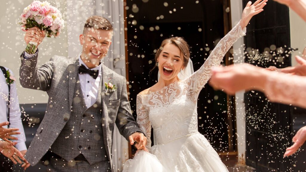 Happy wedding photography of bride and groom at wedding ceremony. Wedding tradition sprinkled with rice and grain