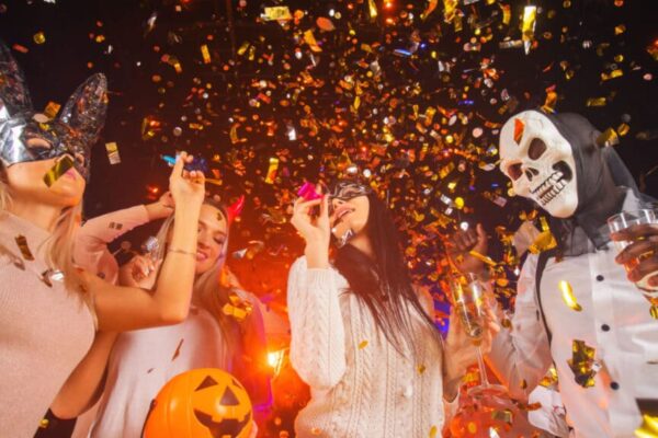 Happy people men and women mixed race dancing together on Halloween party