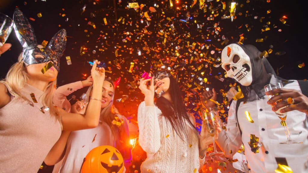 Happy people men and women mixed race dancing together on Halloween party