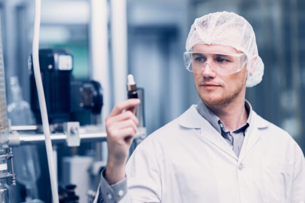 Scientist in Science Lab proudly invented New Medicine Formula. Medical factory staff happy smiling with Concentrate Medical Extract from Plant.