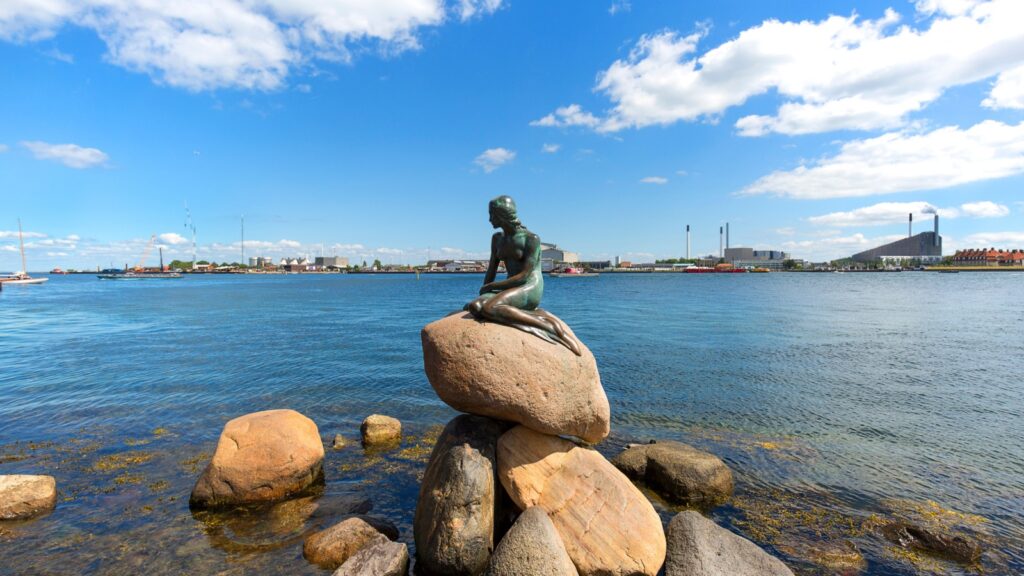 COPENHAGEN, DENMARK - JUNE 22, 2019: The Little Mermaid, bronze statue ,character from the fairy tale Hans Christian Andersen, the symbol of Copenhagen, Copenhagen, Denmark