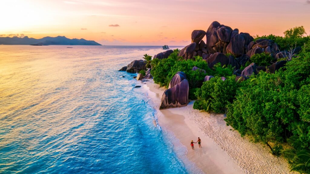 Anse Source d'Argent, La Digue Seychelles, a young couple of Caucasian men and Asian women on a tropical beach during a luxury vacation in Anse Source d'Argent La Digue Seychelles a tropical Island